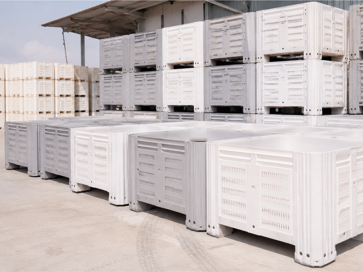 Bins blancos apilados en patio industrial